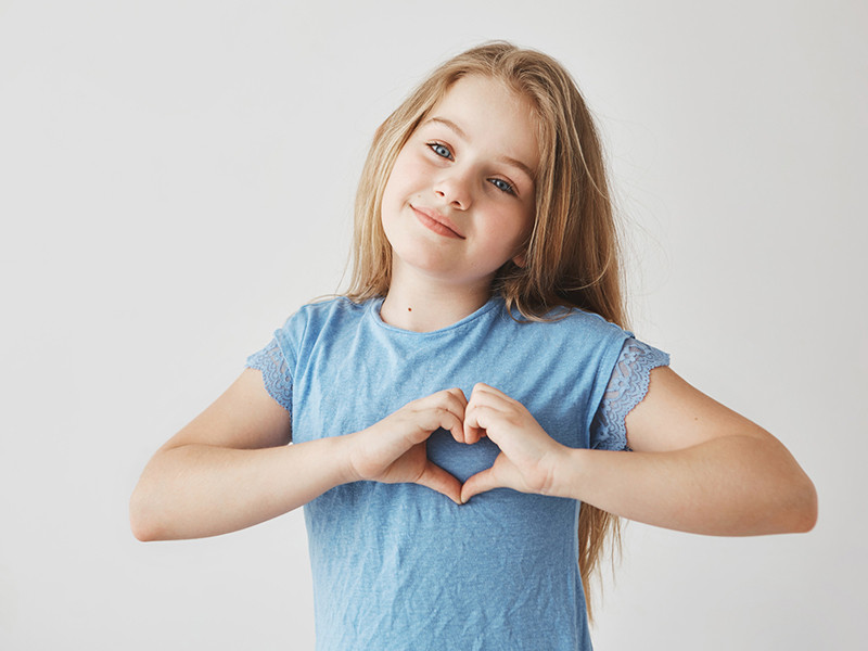 Niña haciendo un corazón con las manos